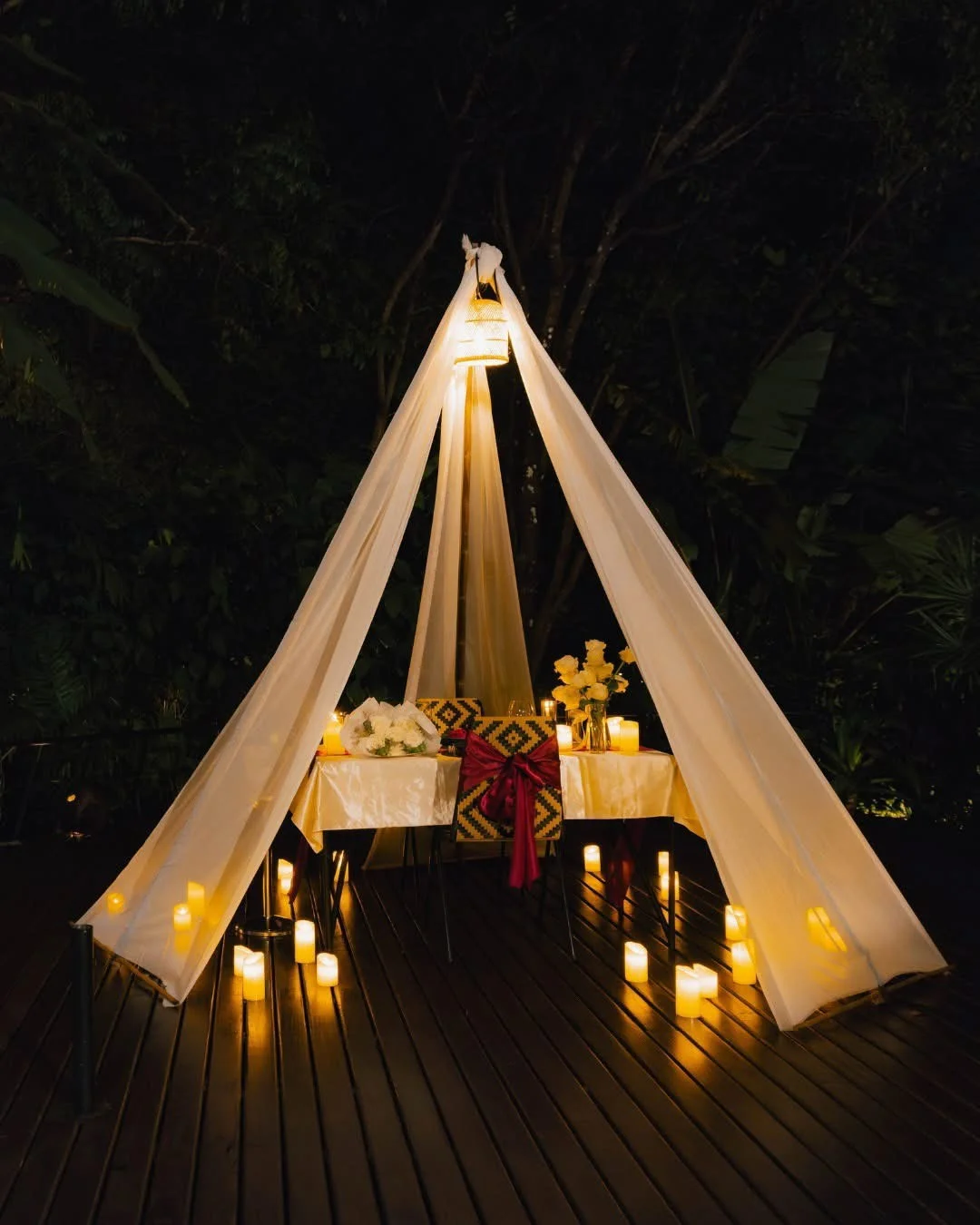 Bamboo pavilion with a decorated dining table and warm lighting