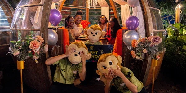 Guests gathered around a birthday cake in a Monkey Dome