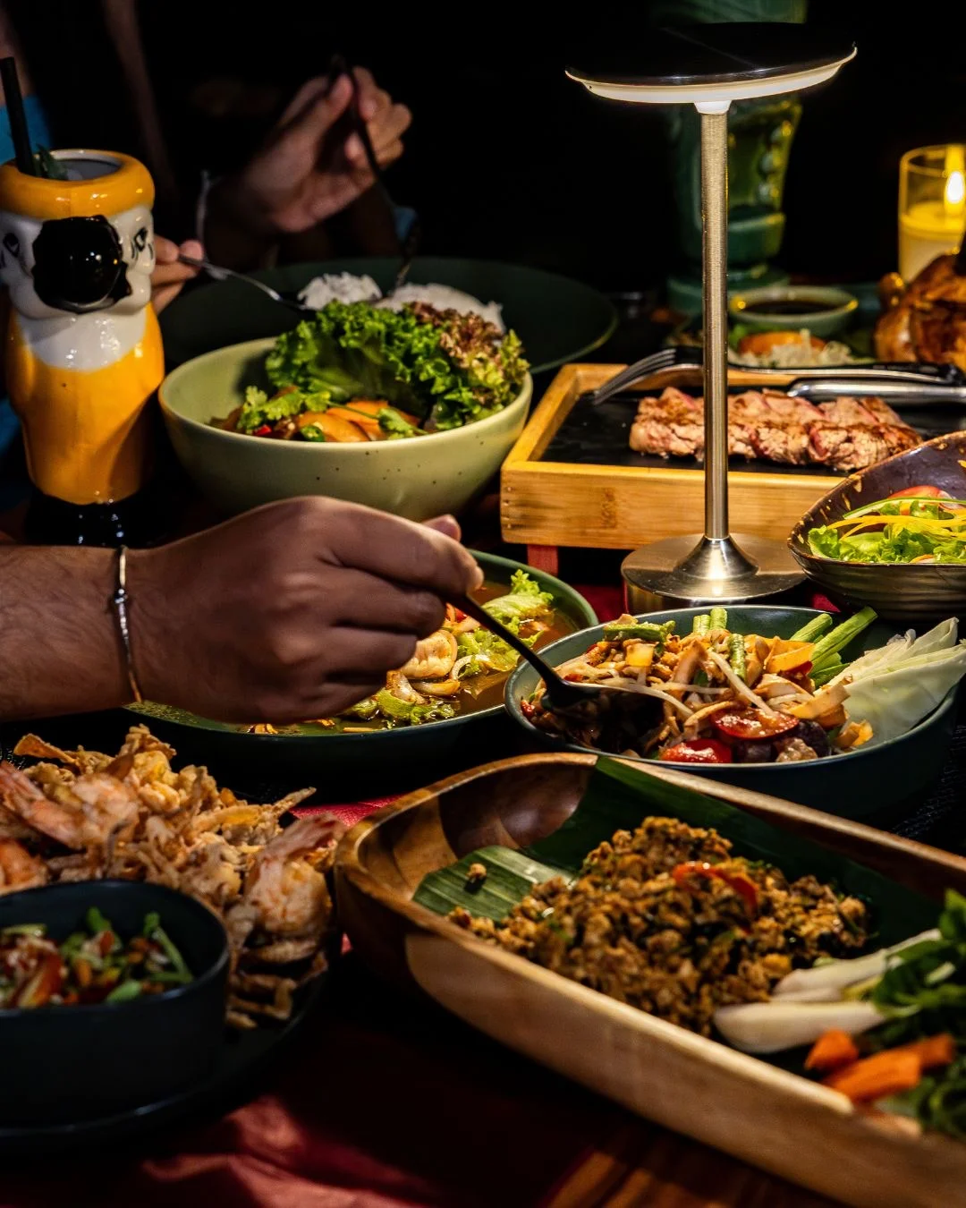 Guests sharing dishes around a softly lit table