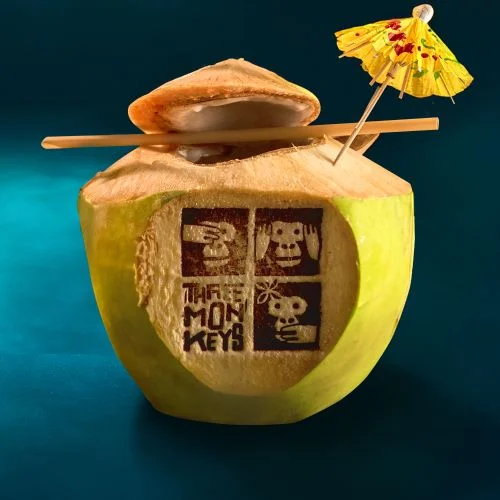 Fresh coconut served with a straw and paper umbrella