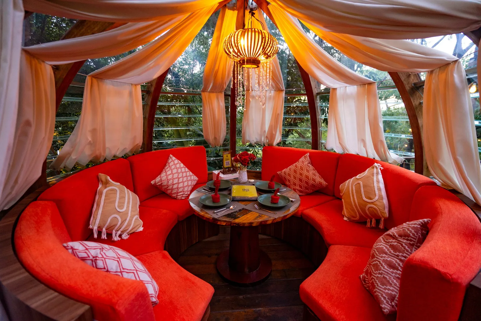 Curved red seating and a round table inside a Monkey Dome