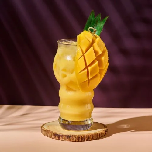 Yellow Mango Coco drink garnished with sliced mango